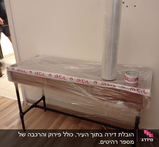 שולחן עטוף בניילון נצמד עם גליל וסרט דבק